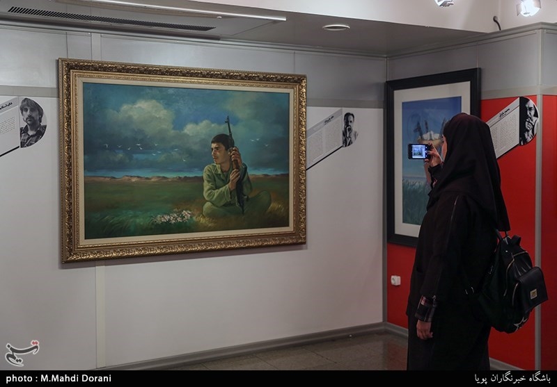 بازدید کننده ای در حال عکسبرداری از آثار نمایشگاه