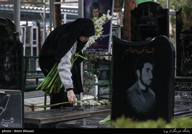 گذاشتن گل روی مزار مطهر شهدا توسط دختران در آیین میهمانی لاله ها