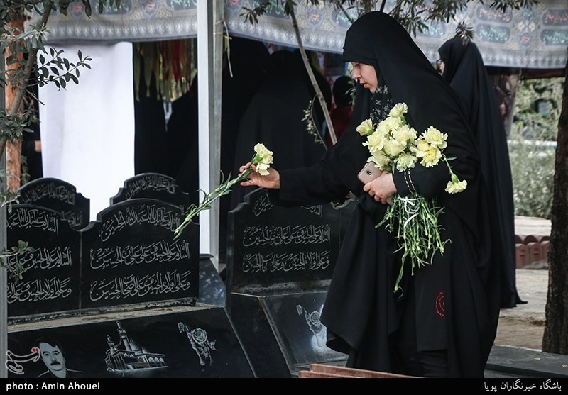 گذاشتن گل روی مزار مطهر شهدا توسط دختران در آیین میهمانی لاله ها