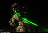 یکی از نیروهای تیپ ویژه صابرین در حال تمرین تیراندازی شبانه است